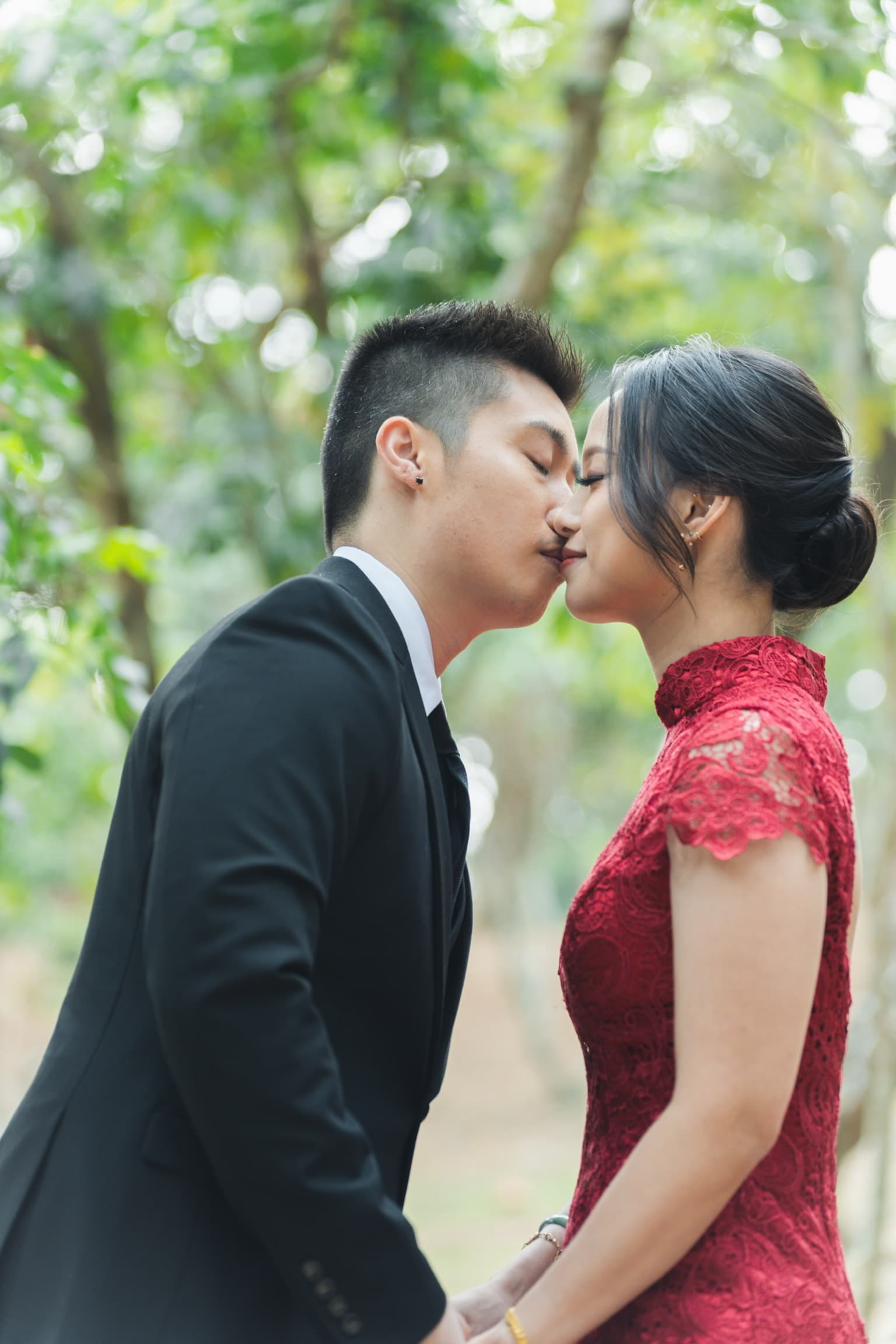 The couple kissing among the trees