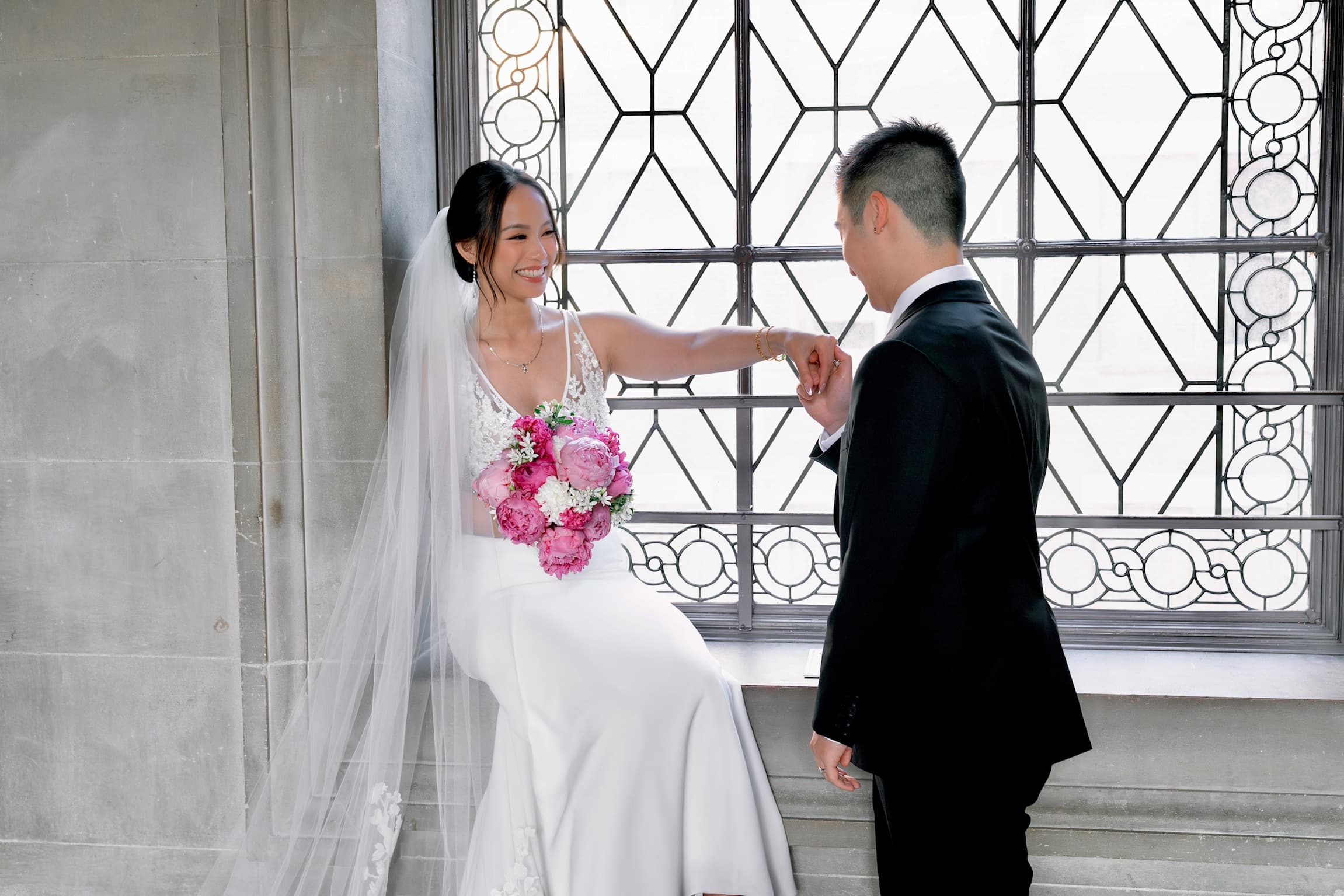 Bride and groom sharing a quiet moment by a leaded-glass window