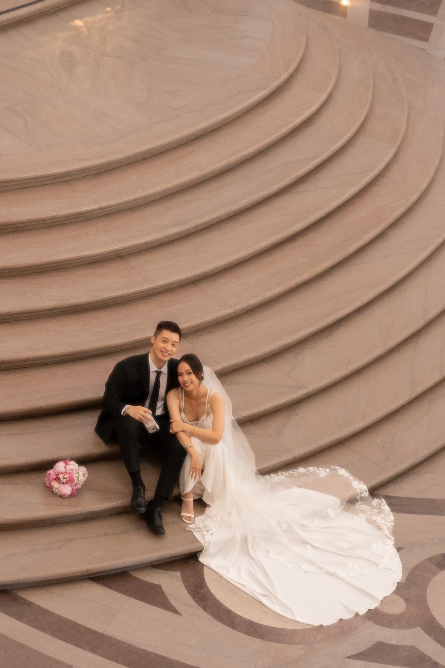 The couple seated together on grand marble steps